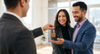 © new - Real estate agent giving house keys to a smiling couple in a new home
