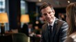 © AdPremium - Handsome Businessman in Formal Suit Smiling During a Meeting in Modern Lounge