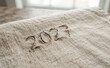 © velikiyzayats - Embroidered year 2027 on rough burlap fabric surface close up, conceptual background for future planning, milestones, and upcoming events in business or personal life