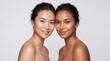 © Giga - Diverse skin tones two women with glowing complexions side by side smiling gently with posed closely together against neutral background