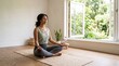 © edivaldo - Woman meditating in lotus pose by open window with garden view