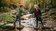 © Bruno Stock - Two children shaking hands while balancing on rocks in a shallow stream during autumn forest exploration
