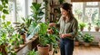 © Segati - Woman watering houseplants in a sunlit room with many green plants