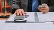 © Mdisk - Smart executive does accounting work, reviewing accounting files prior tax audit, as accounting staff finishes audit tasks, pressing key calculator buttons near desk top.