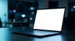 © Ruby - Blank white laptop screen on a dark office desk with cool blue ambient light and bokeh background.