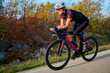© .shock - Female Cyclist Training on Road Bike in Autumn Landscape Fitness Cycling and Triathlon Preparation