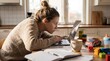 © pithak - Young mother working on laptop at kitchen table surrounded by children toys photography