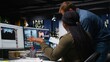 © DC Studio - Creative editing team collaborates on a movie montage using an AI chatbot and post-production software for color grading and video content creation.