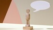 © tashechka - Wooden figure stands on a surface with a speech bubble above it in a simple setting