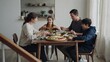 © Graphics Studio.com - A family of four sits together at a wooden table eating a healthy salad lunch with happy family enjoys nutritious salad meal together around dining room table home