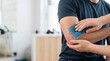 © RAAL - Physiotherapist applying cold gel pack on male patient elbow for recovery