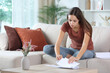 © PheelingsMedia - Woman searching document between letters at home