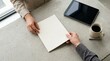 © T A Photos - Person handing blank paper document to colleague on concrete office desk with coffee and tablet