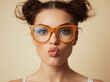 © Mahbub - Close-up portrait of a playful young woman wearing orange glasses and puckering her lips.