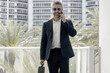 © Volodymyr - Business man talking on the phone outdoors. Confident man making a call. Executive in suit on a phone call. Serious business man discussing strategy. Business man talking on a mobile. Business calls.