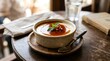 © Wellington - A delectable dessert of creme brulee, topped with fresh mint and a glistening caramel sauce, is presented in a rustic bowl on a wooden table, inviting a moment of sweet indulgence.