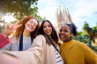 © CarlosBarquero - Young funny only women friends taking selfie in front of Sagrada Familia in Barcelona. Beautiful mixed race girl on street of European city enjoying vacation happy and smiling. Funny tourism people