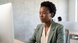 © Andreas - African american businesswoman working on desktop computer in modern office