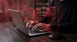 © Muzamil Mustafa - Person typing on a laptop with red digital security warning alerts in a dark room with holographic warning notifications notifications about unauthorized unauthorized access critical person types