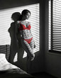 © PANDORA ILARE - Stylized figure in red lingerie and heels, bending forward to adjust black fishnet stockings. Minimal white-and-black background highlights the bold red tones and the clean, graphic composition.