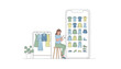 © Polash - Woman sitting on a stool and checking a fashion shopping application on her tablet with a clothes rack standing beside her on floor.