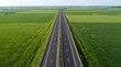 © Rozie - Aerial top view of a modern asphalt highway through lush green fields