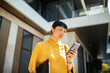 © Davor - Focused businesswoman using smartphone outside modern office