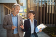 © Davor - Two business colleagues discussing strategy outside office building