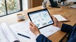 © Lee - Real estate agent analyzing property portfolio performance on tablet device, holding digital dashboard with charts and graphs, architectural blueprints spread on wooden desk