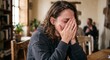 © Studiotwentysix - Sad young woman crying and covering her face with her hands at home.