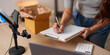 © Natee Meepian - Cropped view of entrepreneur writing order details on clipboard for e-commerce business