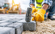 © Oleksiy - Construction worker laying stone pavers with rubber mallet on sand base