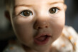 © Ananass - Tiny baby stares wide eyed with wonder at camera capturing pure innocent moment in soft warm light