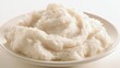 © Chingiz - Mashed potatoes served on a plate, simple white backdrop.