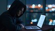 © Arfa_Media - Hacker in a hoodie working on a laptop in the darkness at night for cybersecurity programming and digital security