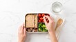 © AspctStyle - Healthy bento lunch box preparation with whole wheat sandwich, fresh vegetables, and fruit on marble table, capturing balanced diet and clean eating for nutrition and wellness marketing.