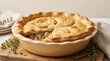 © lYD - Homemade savory beef pie with golden crust on wooden board.