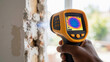 © Lubov - Professional hand holding a thermal imaging camera to inspect a wall for heat loss. Infrared scanner shows a temperature map during a home energy audit
