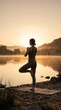 © Hirushan - Woman practising yoga on a mat at sunrise beside calm water