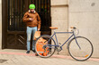© Oscar - Delivery rider using phone while holding food at a doorstep