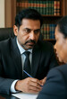 © Pixel-Shot - Legal consultation and professional advice, serious lawyer discussing contract terms with client in law office with law books in the background