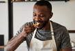 © Pixel-Shot - Culinary quality control and food tasting, professional chef testing a dish in a restaurant kitchen with focus and satisfaction for gourmet cooking