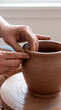 © Rendara Studio - Steady hands raise tall clay vessel from wheel with careful precision skill