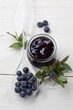© Westend61 - Glass of blueberry marmelade and some berries on plastic spoon, studio shot