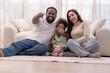 © ultramansk - A cheerful interracial family laughs together during floor playtime in an airy white home, as the children play happily ideal for parenting and wellbeing content.