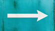© Екатерина Чумаченко - White direction arrow painted on turquoise blue grunge textured metal wall