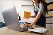 © Natee Meepian - Entrepreneur processing online order with laptop and cardboard box for e-commerce