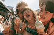 © Thanakorn - Happy Asian family enjoying ice cream outdoors, young girl with messy face laughing between parents, sunlight, summer day, joyful, candid, bonding moment