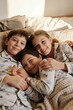 © Светлана Ефименко - Happy Siblings Relaxing Together in Bed During Cozy Morning at Home