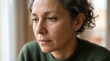 © primipil - Sad mature woman crying with teardrop on face looking through window at home. Concept of grief, depression, tear, sadness, upset, mental health, weeping, sorrow.